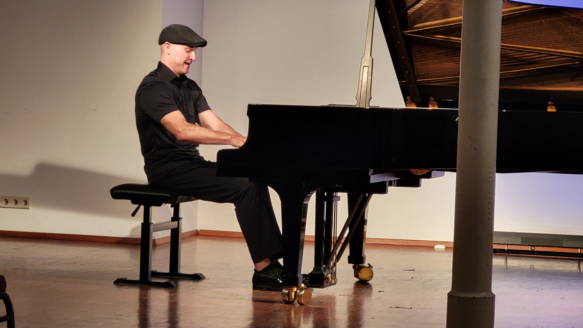 Matthew Mayer performing on a grand piano in an intimate hall in Vienna, Austria