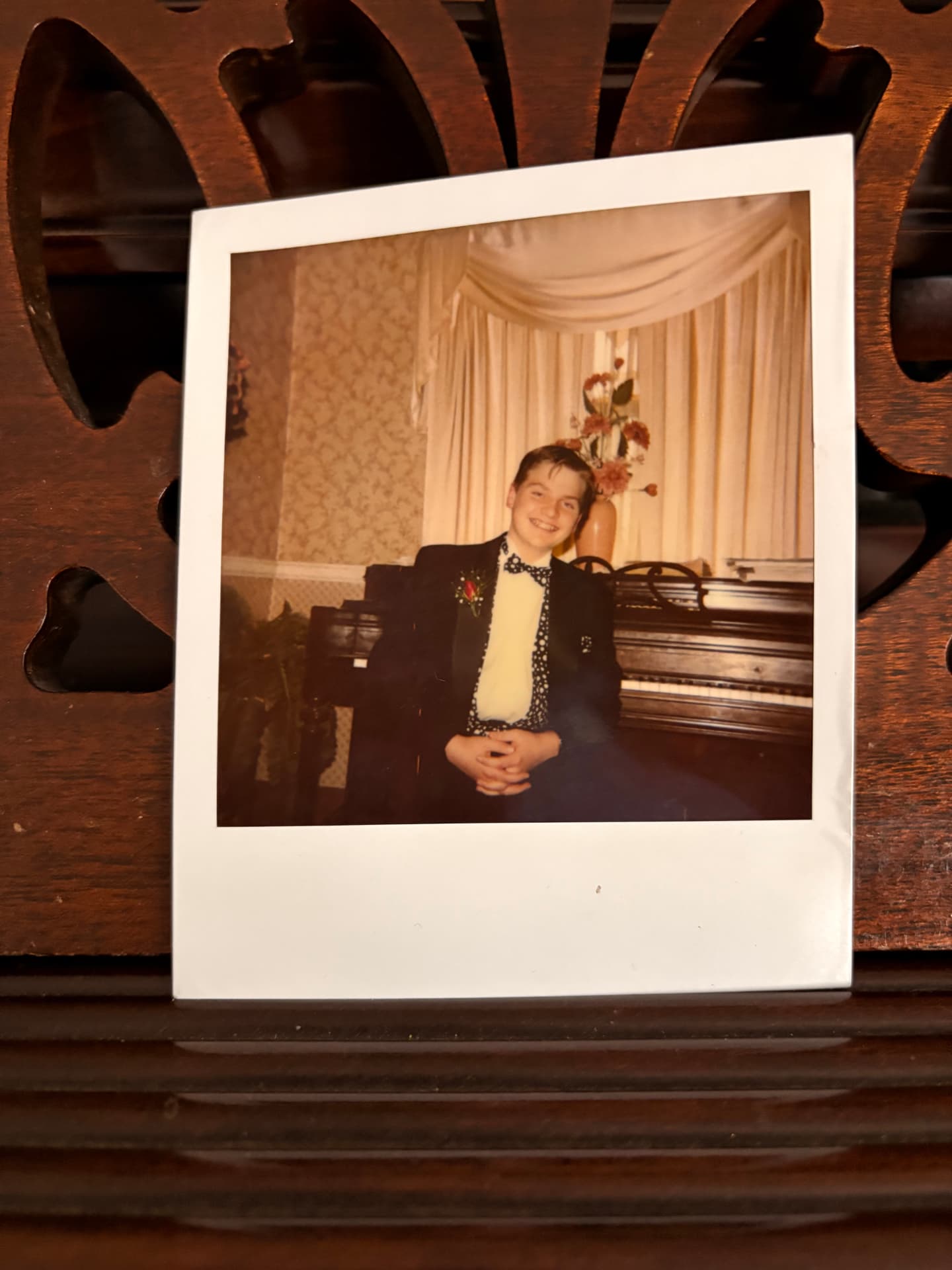 Matthew Mayer as a child standing beside an upright piano