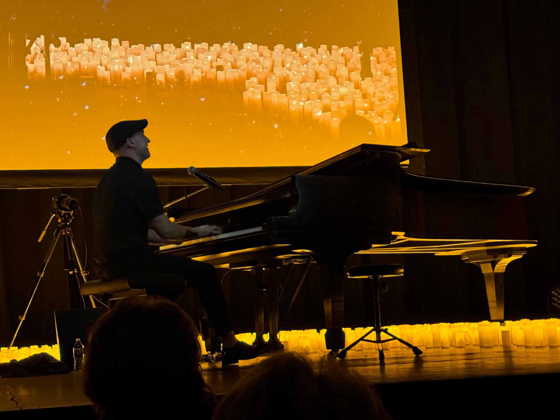 Matthew Mayer performing on a grand piano on a stage bathed in golden candlelight, South Dakota